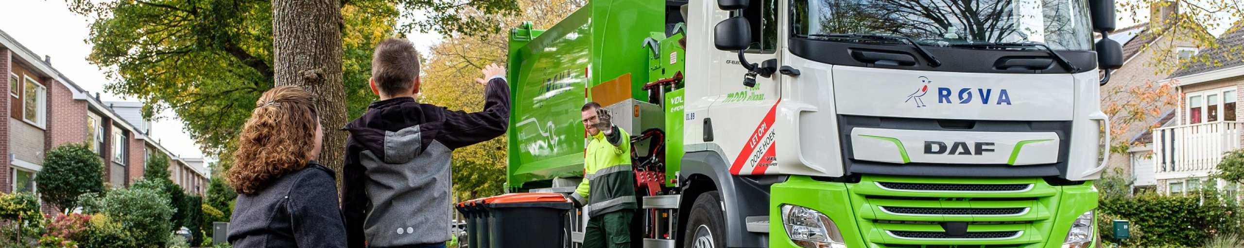2 kinderen die naar een ROVA vuilniswagen zwaaien