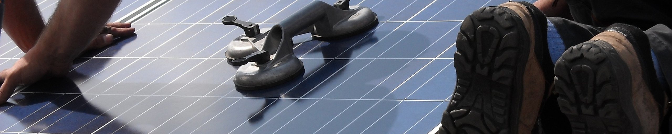 Twee mannen leggen zonnepanelen op een dak