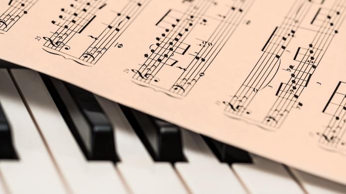 Pianotoetsen met bladmuziek