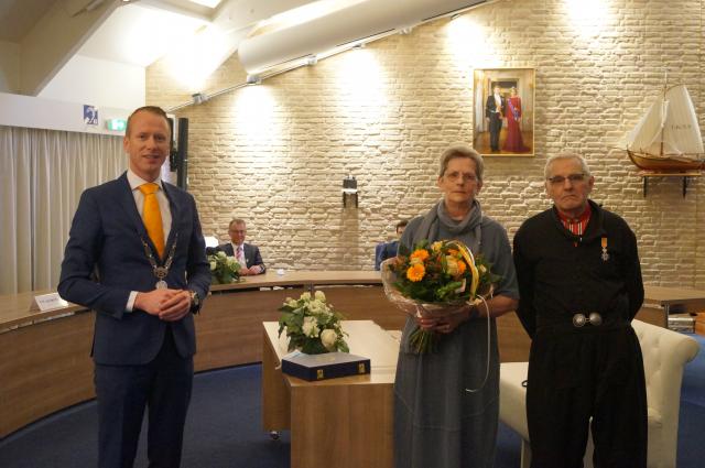 Links op de foto Burgemeester Cees van den Bos, die een Koninklijke Onderscheiding heeft uitgereikt aan Age Koffeman, rechts op de foto. Links van hem zijn zus Tinie Snoek-Koffeman