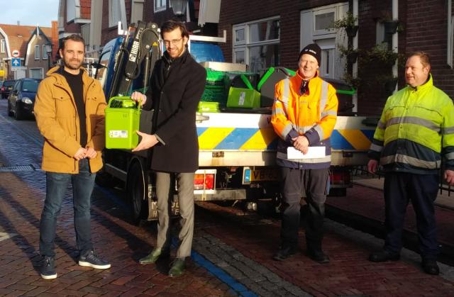 Wethouder Middelkoop reikt de eerste biobak uit aan Hessel van de Berg, bewoner van het oude dorp.